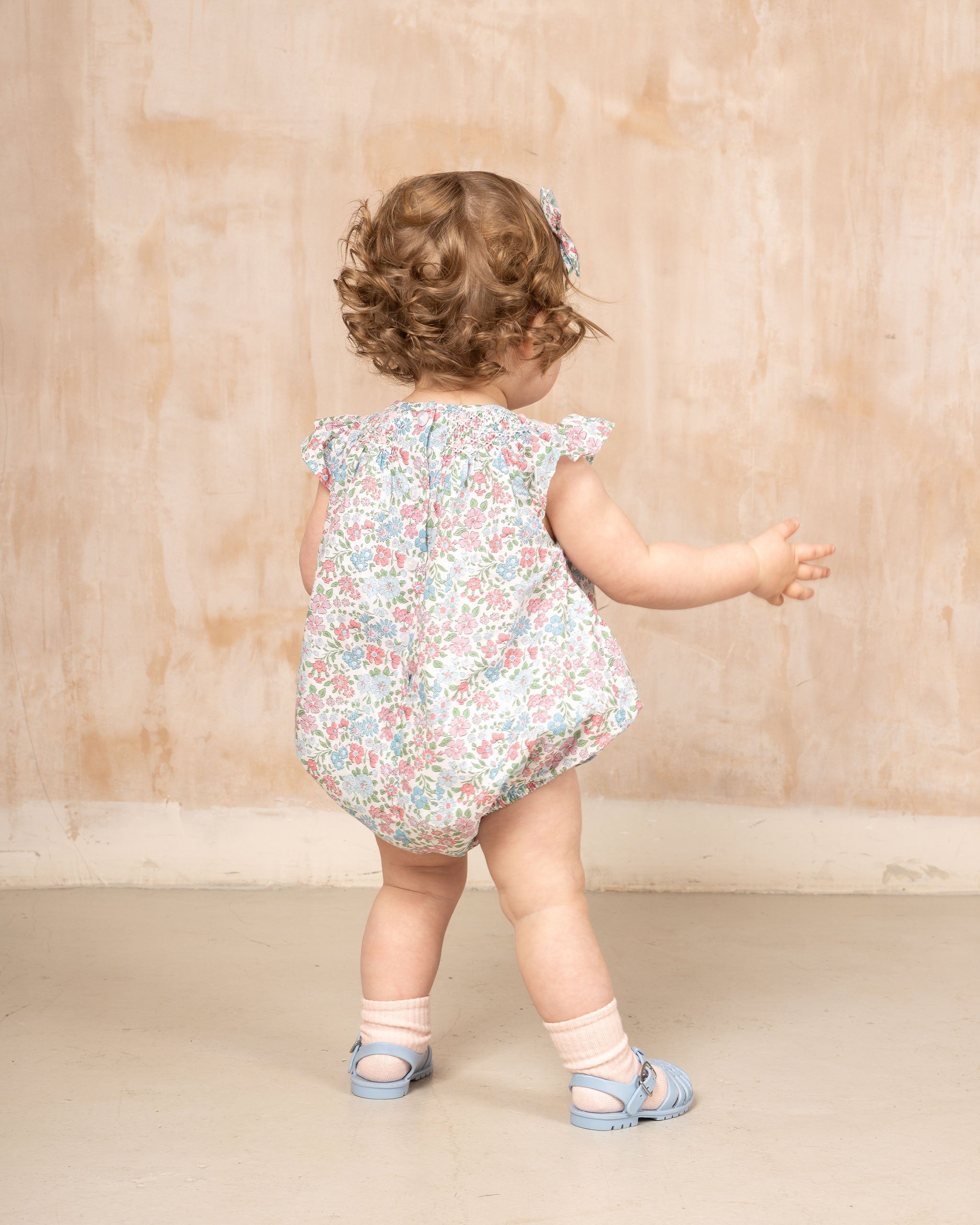 baby from back in floral romper