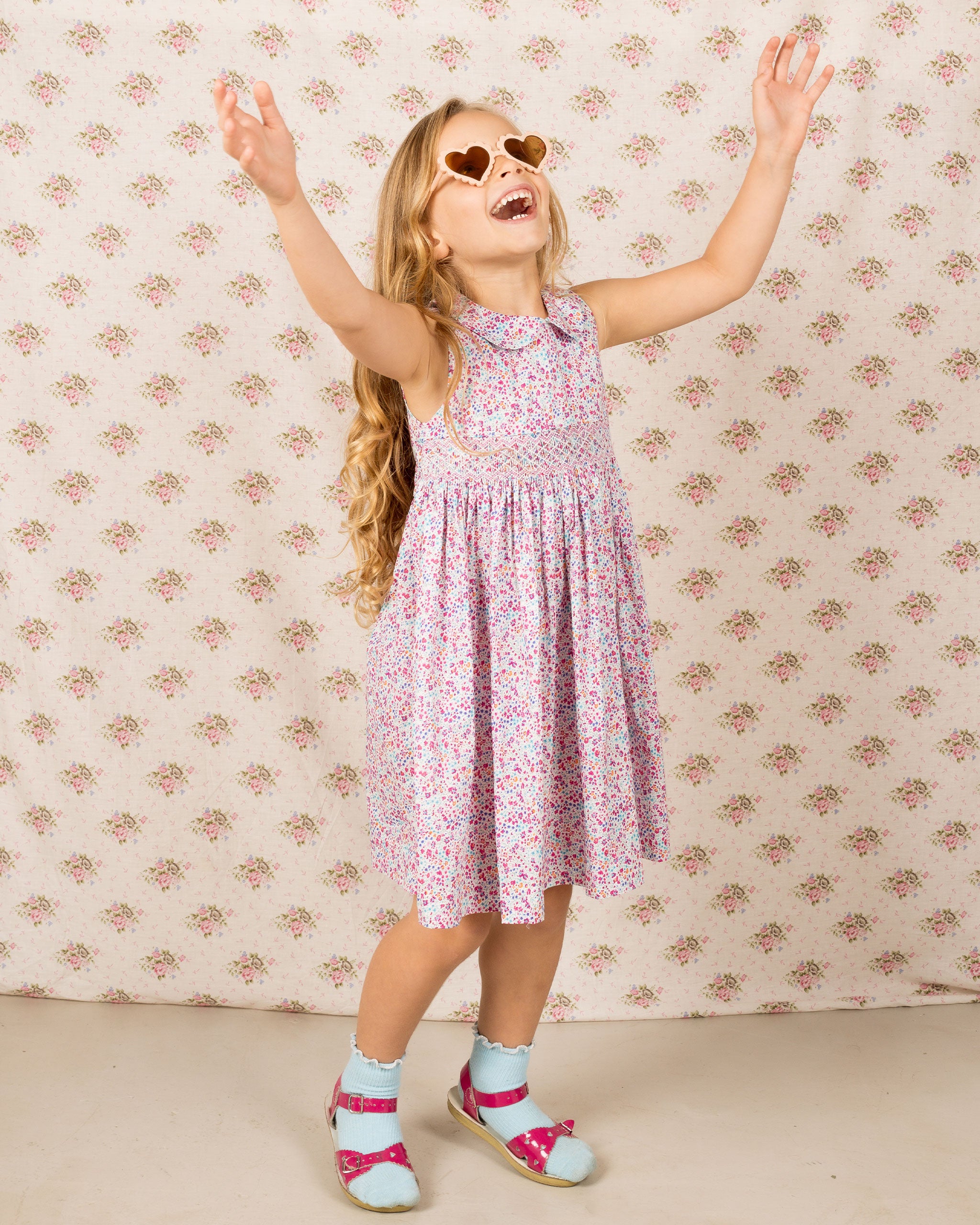 girl having fun in a pink floral summer dress