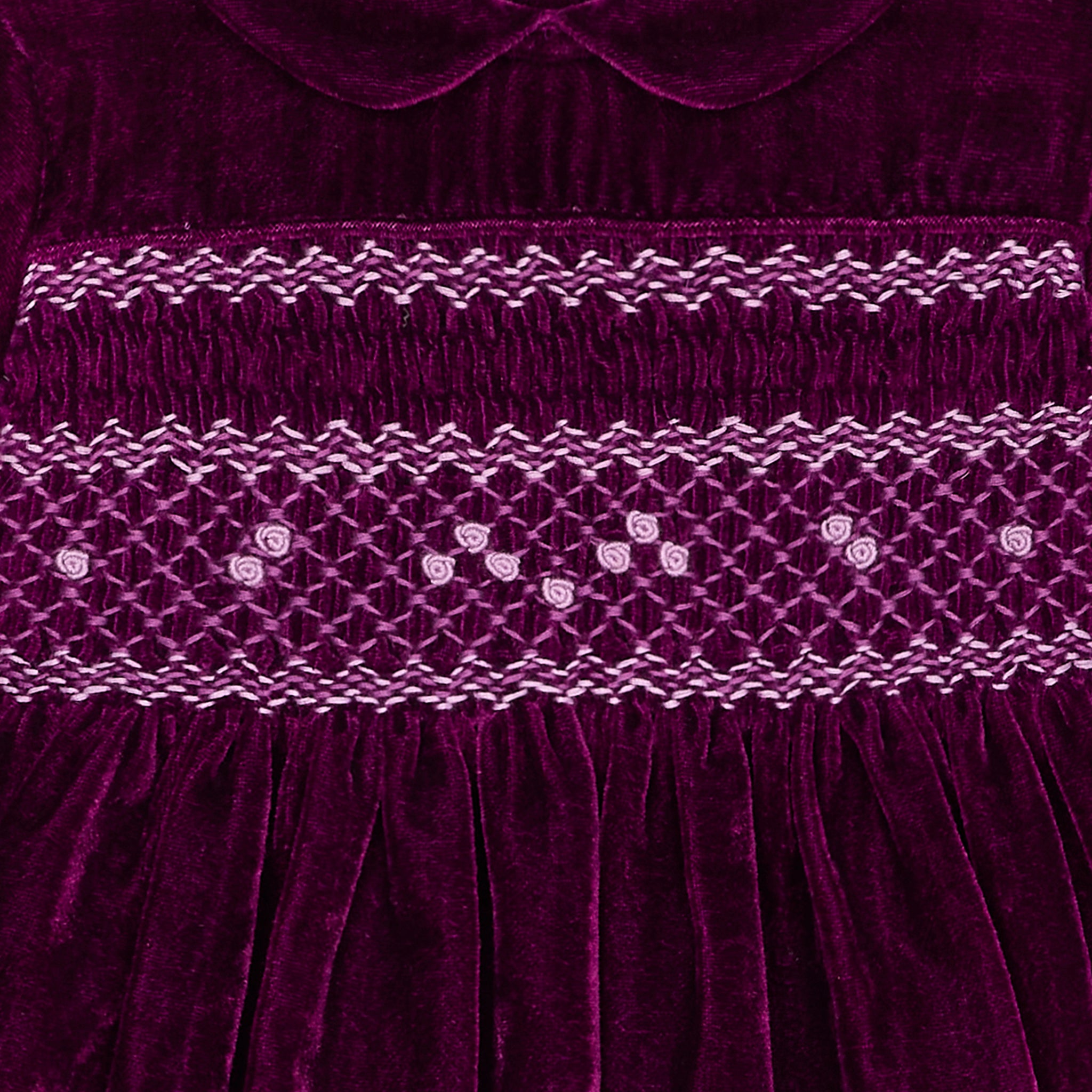 Close-up of a purple velvet fabric with intricate stitching pattern