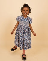 girl wearing floral smock dress, white and navy