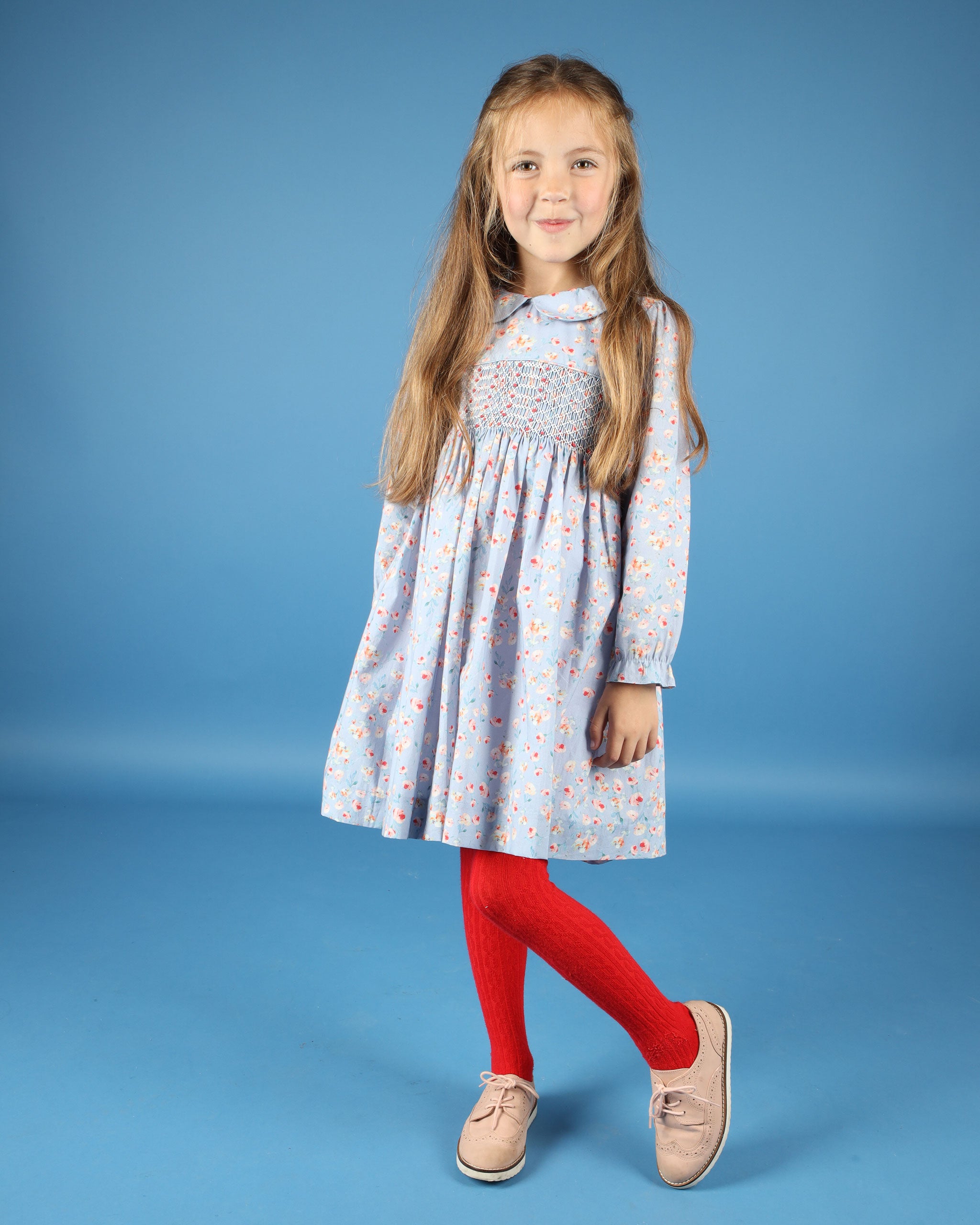 girl wearing hand-smocked dress in pale blue florl