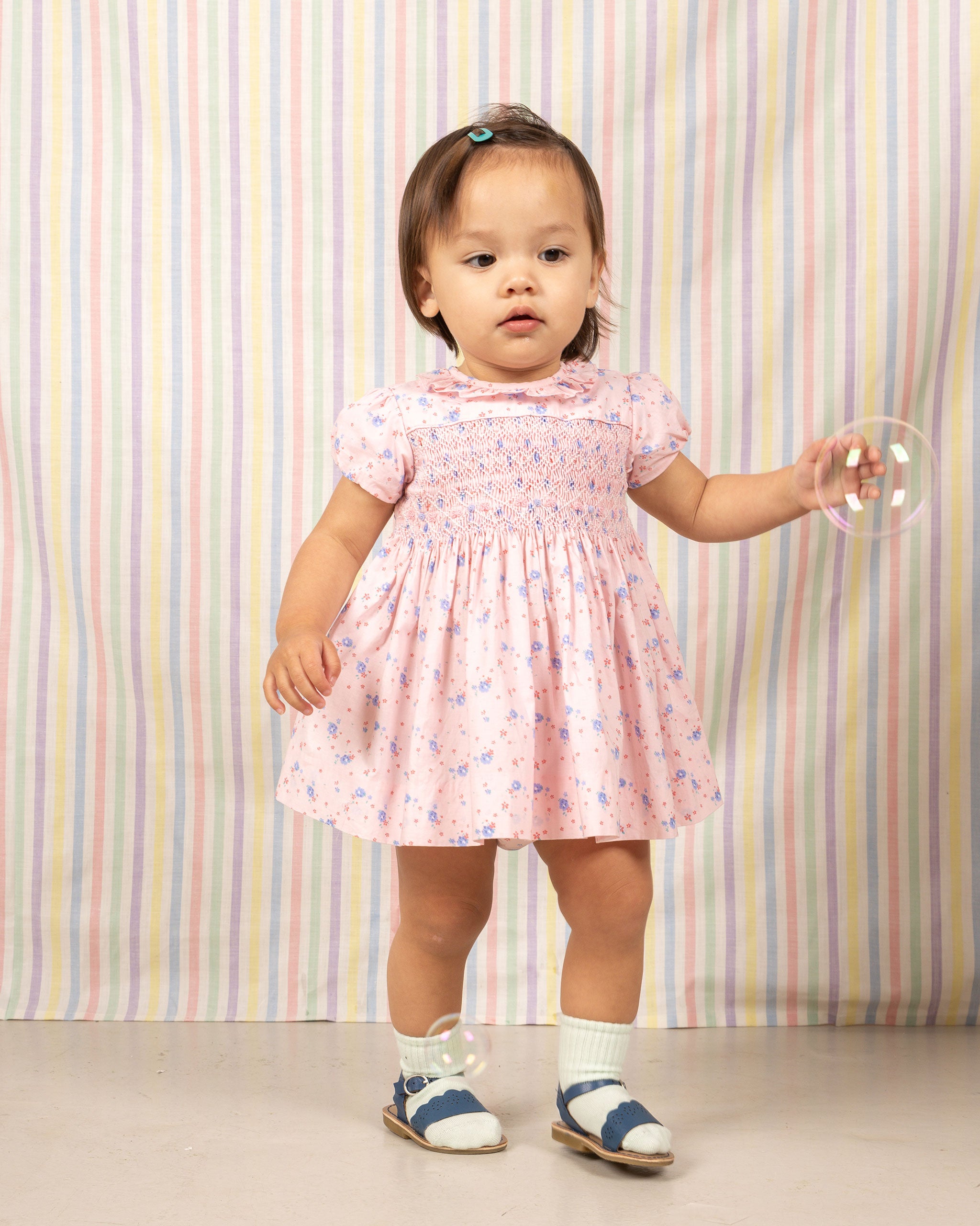 baby in pink smock dress