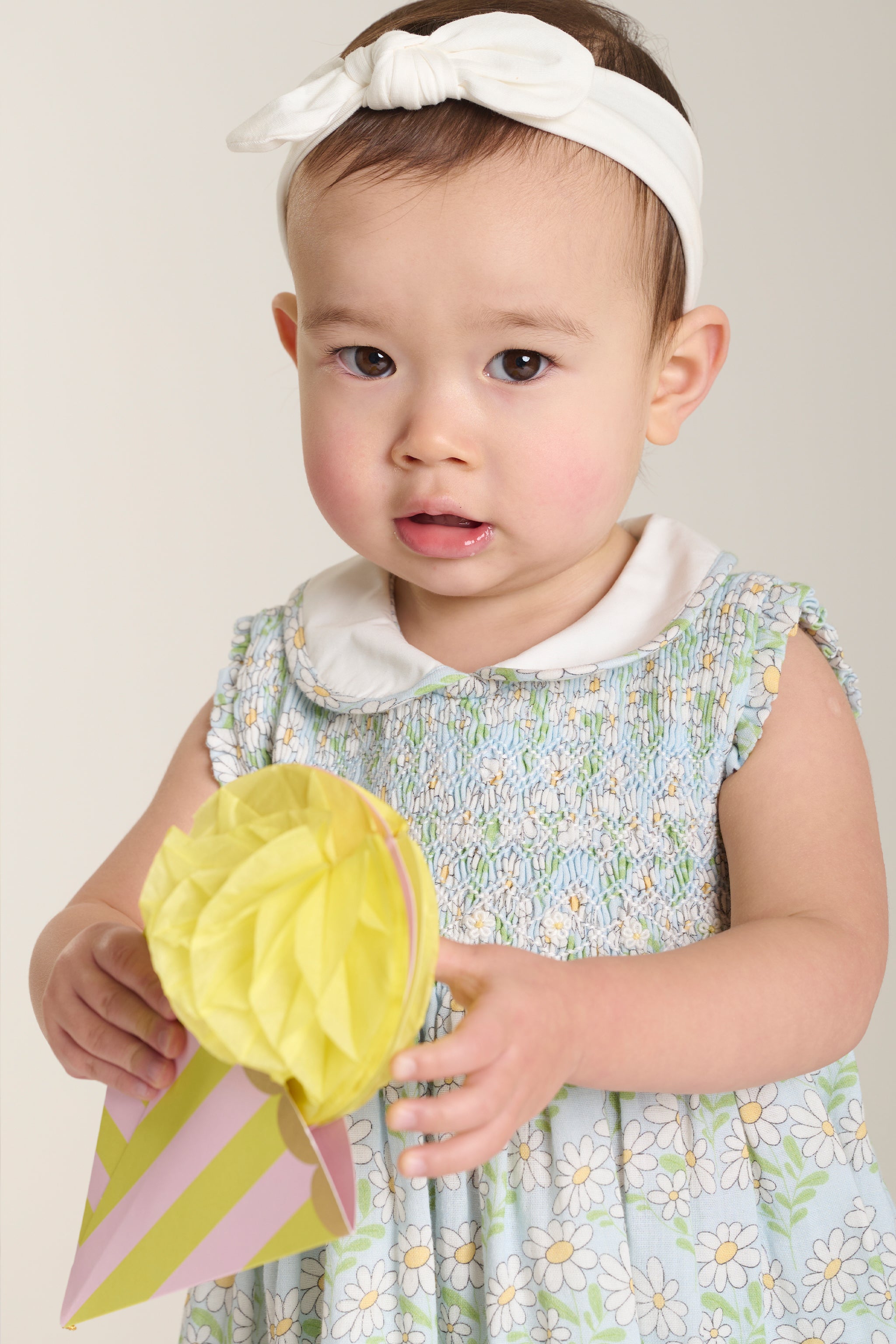 Baby in hand-smocked daisy print dress