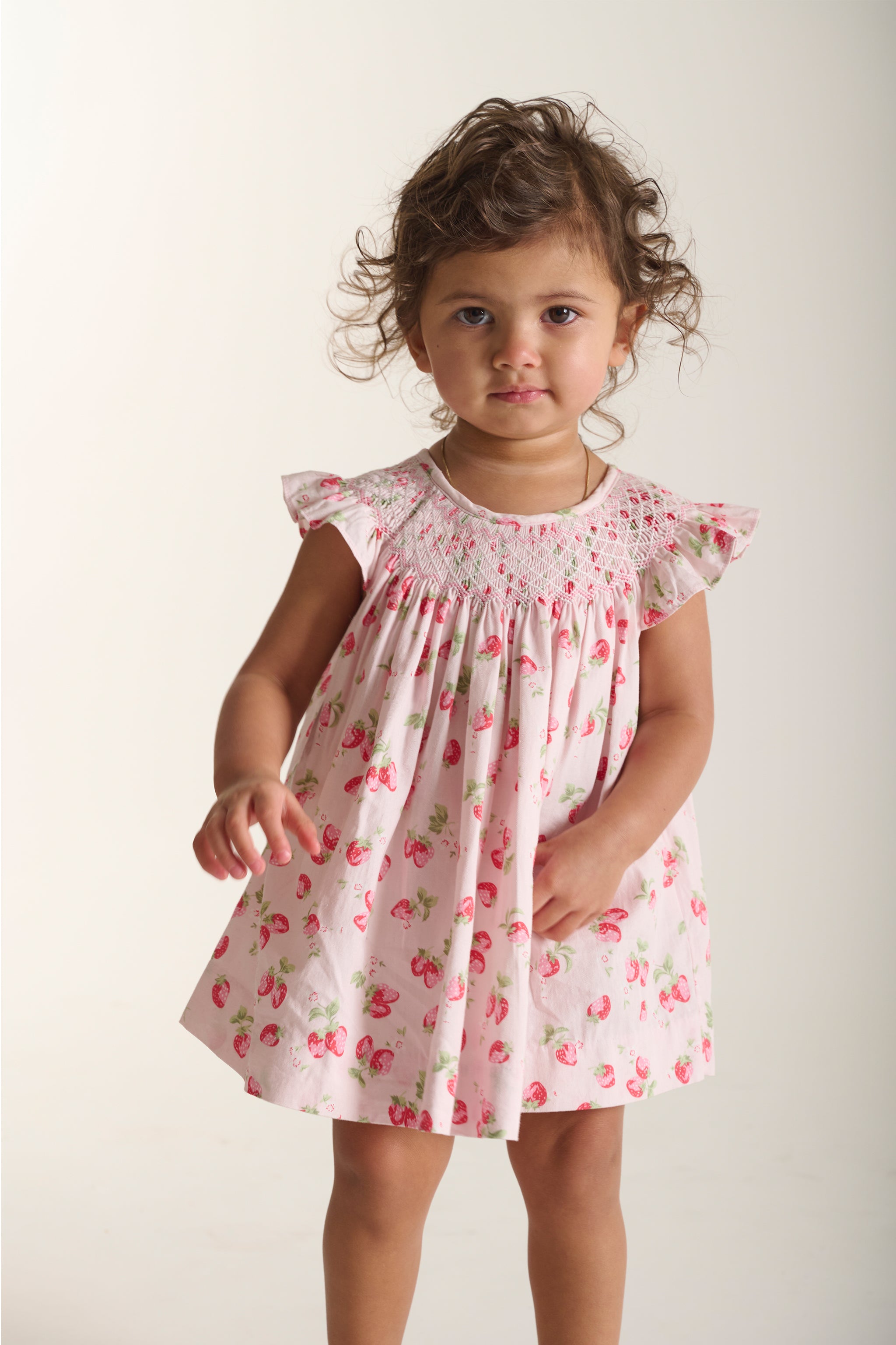 toddler in strawberry smock dress
