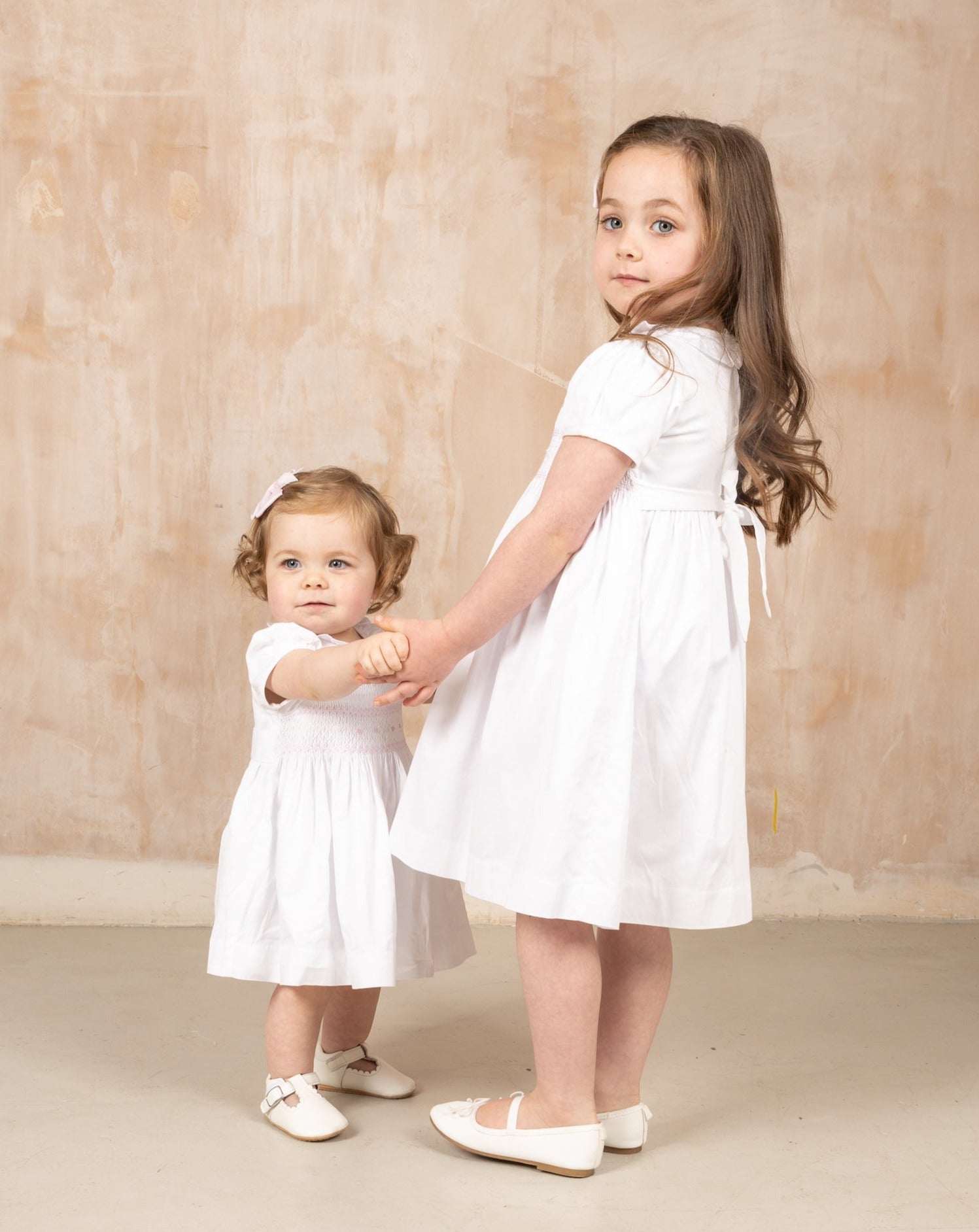 baby and big sister in white occasional dress