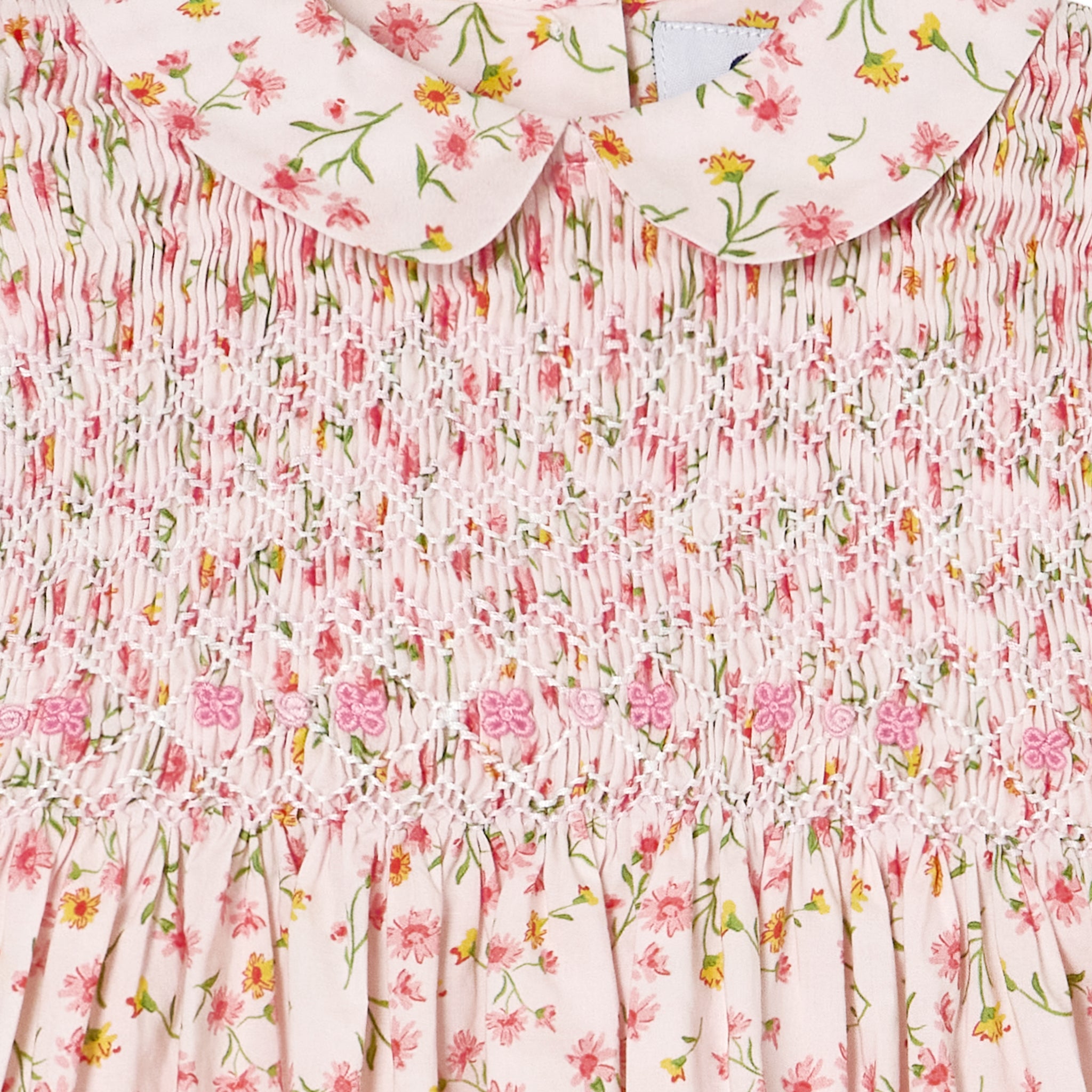 closeup pink floral dress with hand smocking