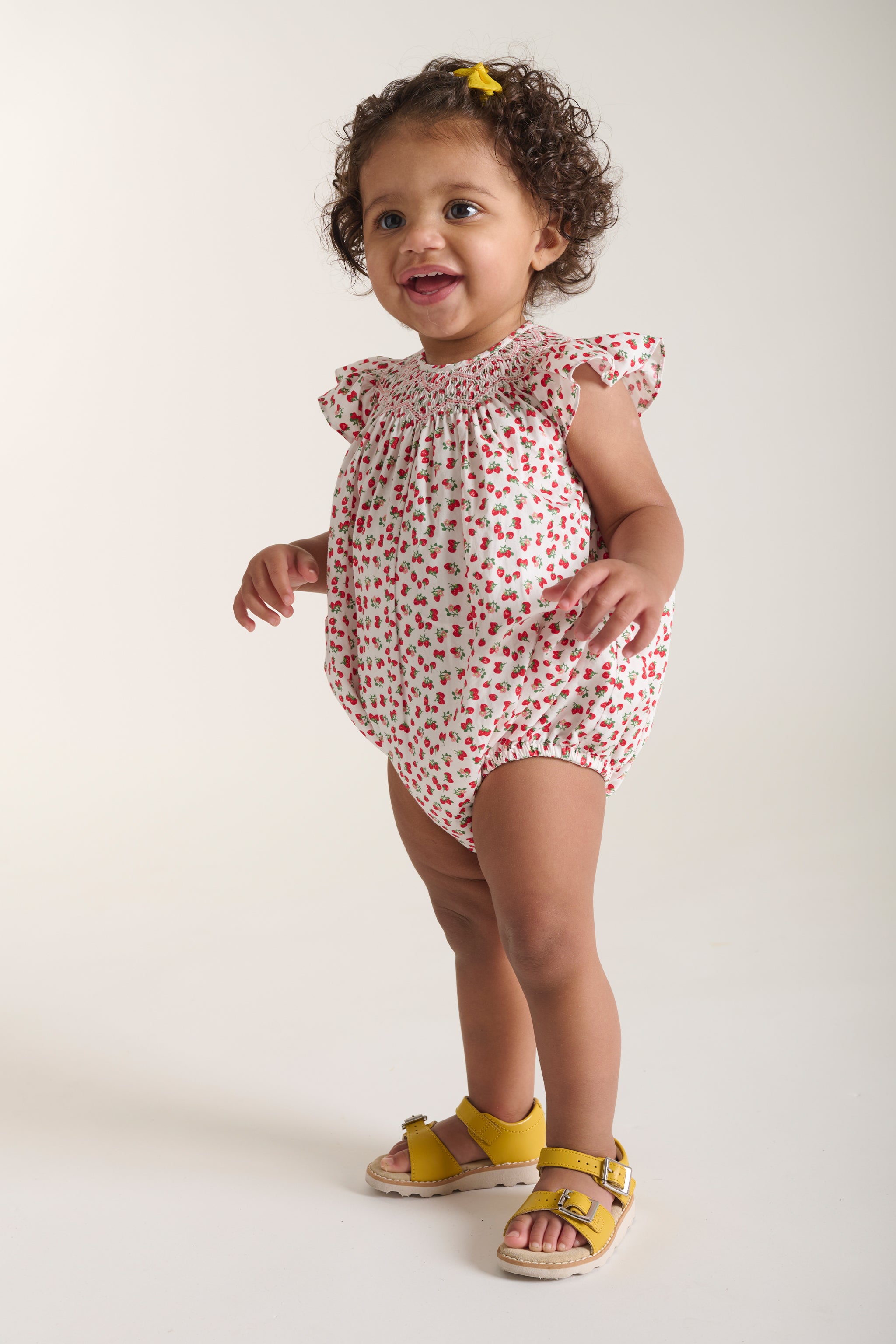 toddler in strawberry romper