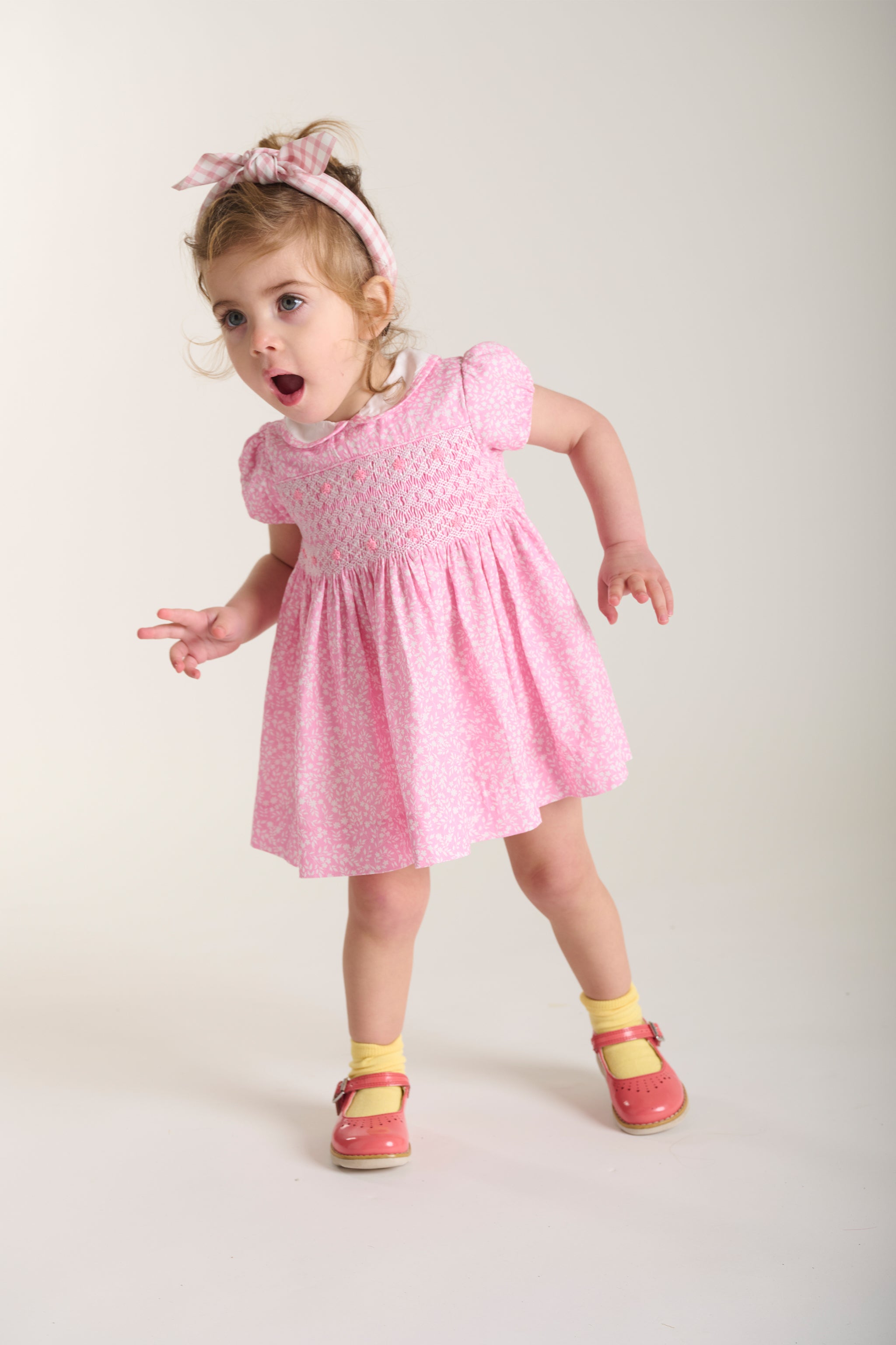 smockde dpink dress worn by toddler girl
