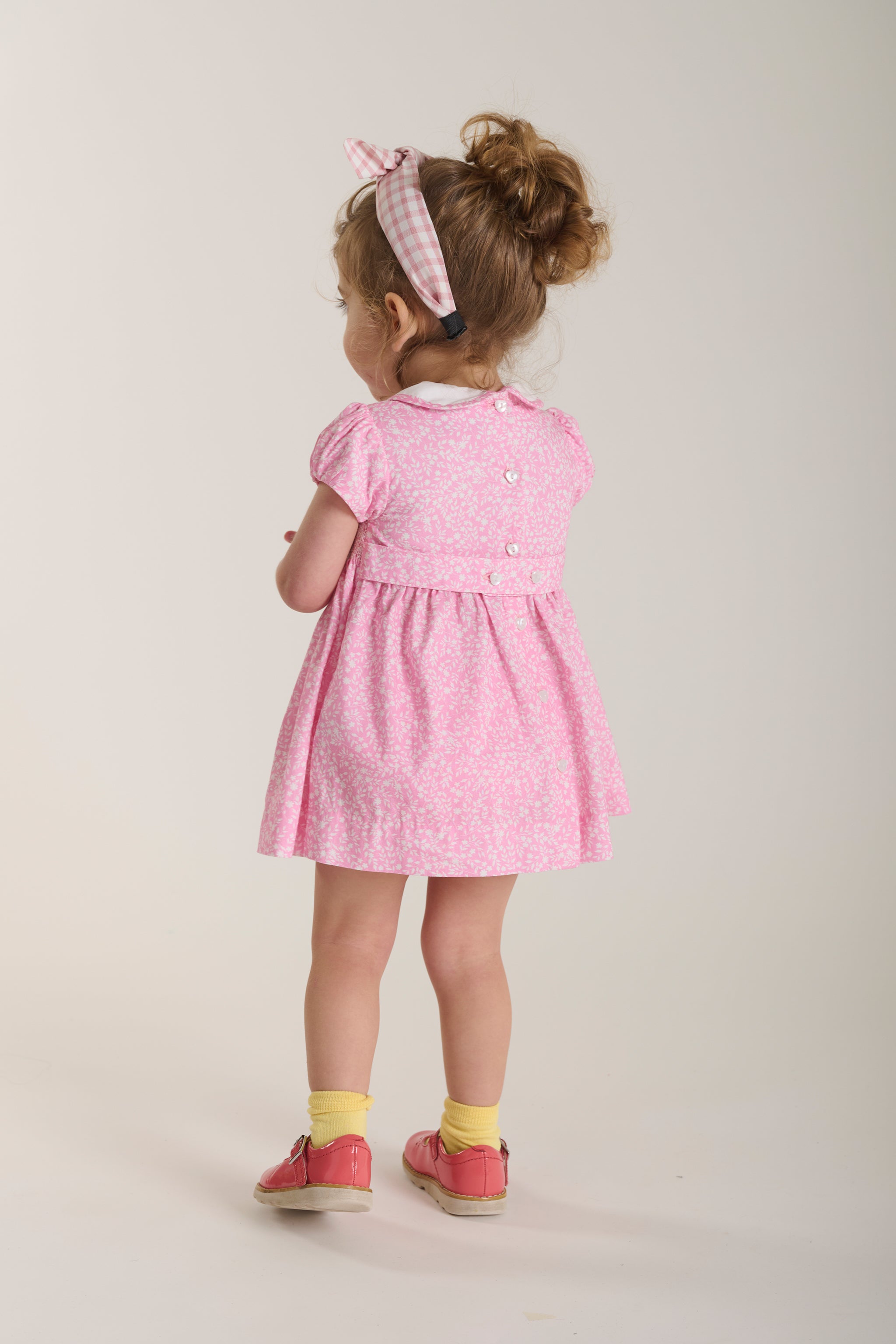 toddler in pink dress back view
