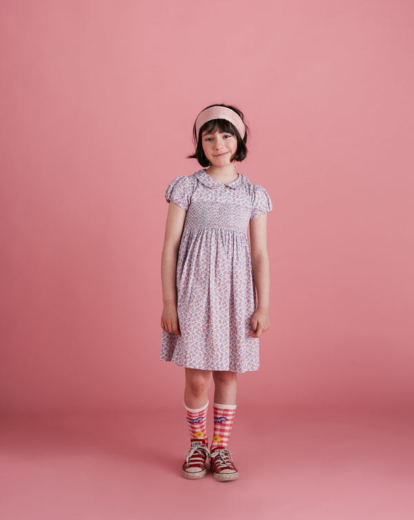 girl wearing hand-smocked summer dress, pastel colours