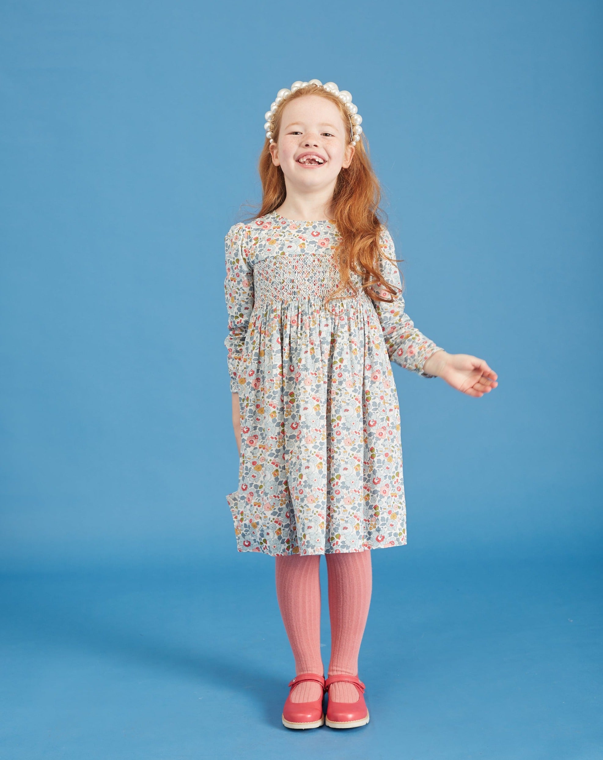 girl wearing hand-smocked Liberty Print dress