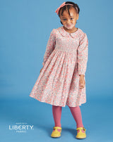 girl modelling smocked dress made from Liberty fabric