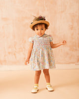 baby in floral smock dress