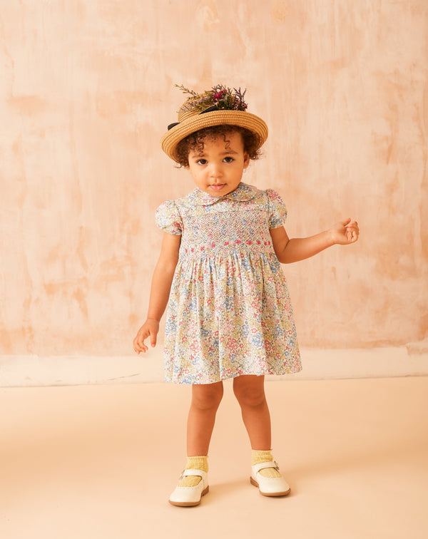 baby in floral smock dress