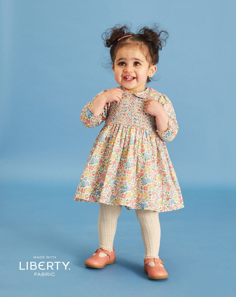 toddler in floral long sleeve smock dress made from Liberty fabric