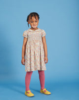 girl wearing Liberty print dress with hand-smocked bodice, floral fabric