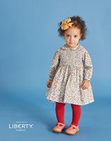 toddler girl wearing hand-smocked dress made from Liberty fabric