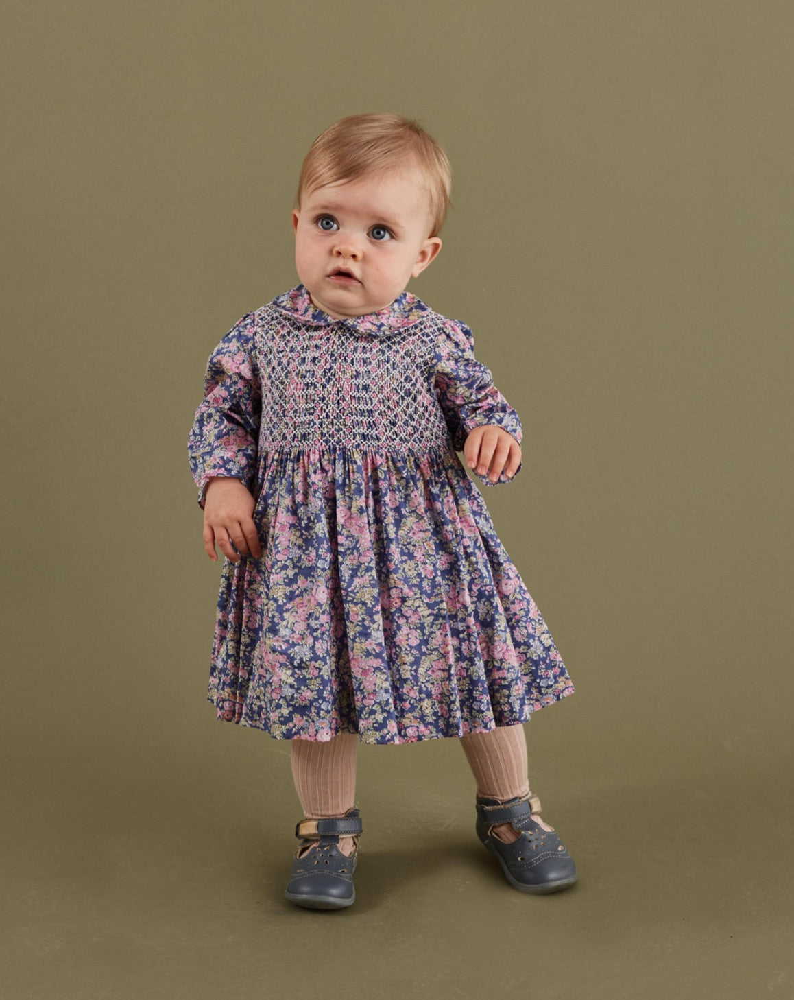 baby girl wearing a floral smocked dress